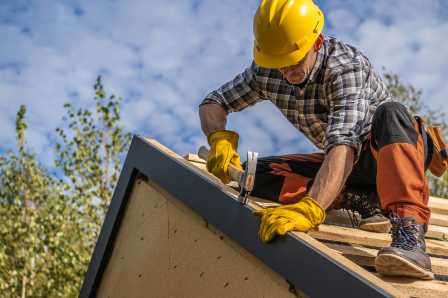 Roofer wearing gloves working on shingle installation
